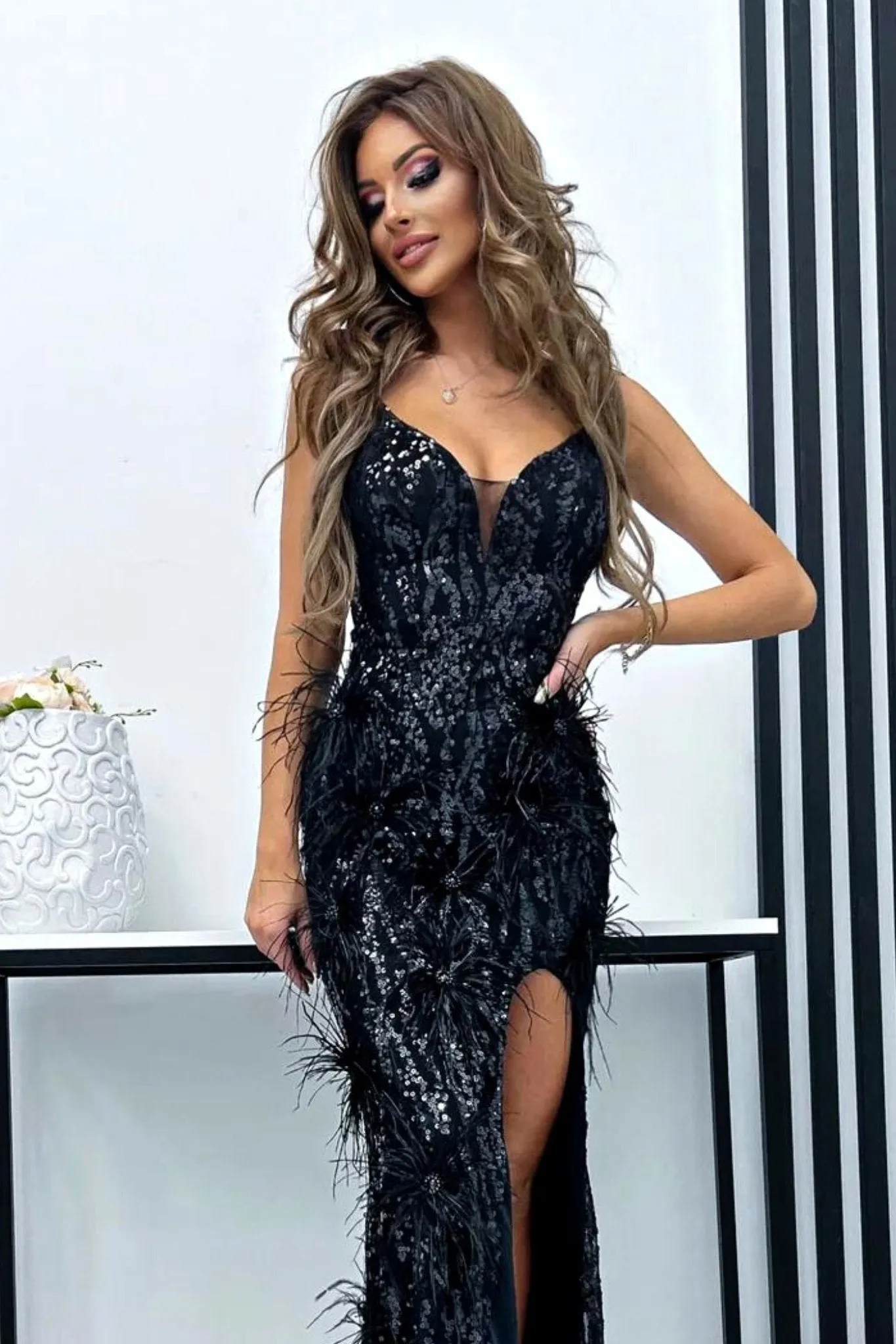 Abito lungo aderente nero con decorazioni in paillettes colore nero piume e strass